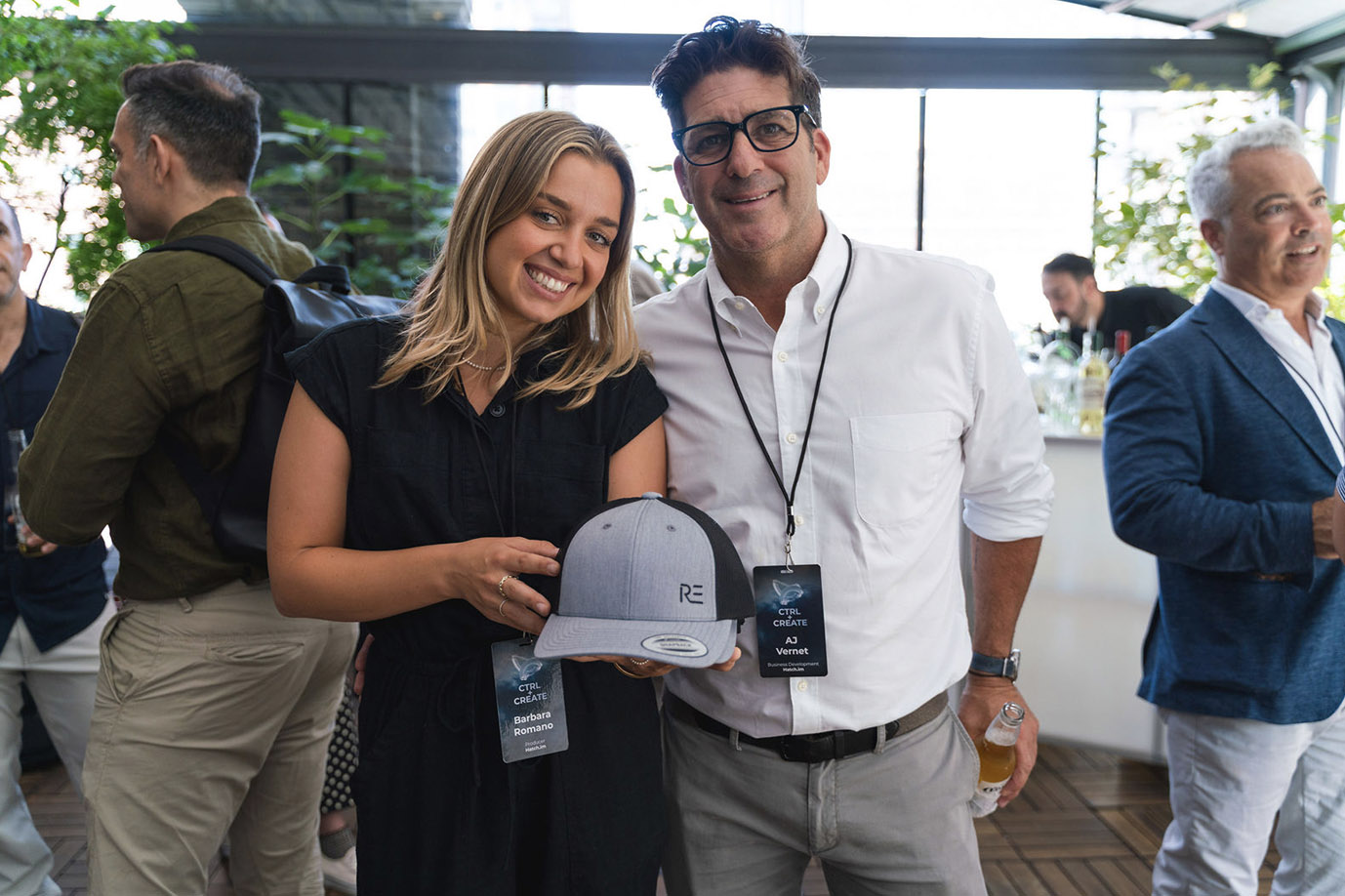 Event guests wearing printed badges and holding branded caps